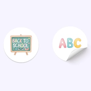 May include: Two round stickers with a school theme. One sticker features a small chalkboard with the words "BACK TO SCHOOL" and a cute face. The other sticker has the letters "ABC" in pastel colours.