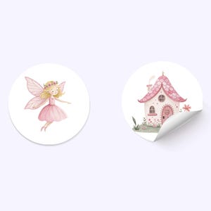 K&ouml;nnte beinhalten: Zwei runde Aufkleber mit Aquarelldesign. Ein Aufkleber zeigt eine rosa Fee mit Fl&uuml;geln und einer Blumenkrone. Der andere Aufkleber zeigt ein rosa Haus mit einer wei&szlig;en T&uuml;r und einem Schornstein.
