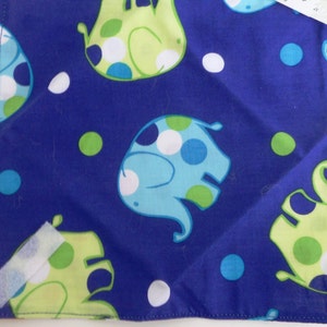 May include: Square blue fabric with a repeating pattern of cartoon elephants in light blue and lime green with white polka dots. The elephants are set against a dark blue background with white and green polka dots.