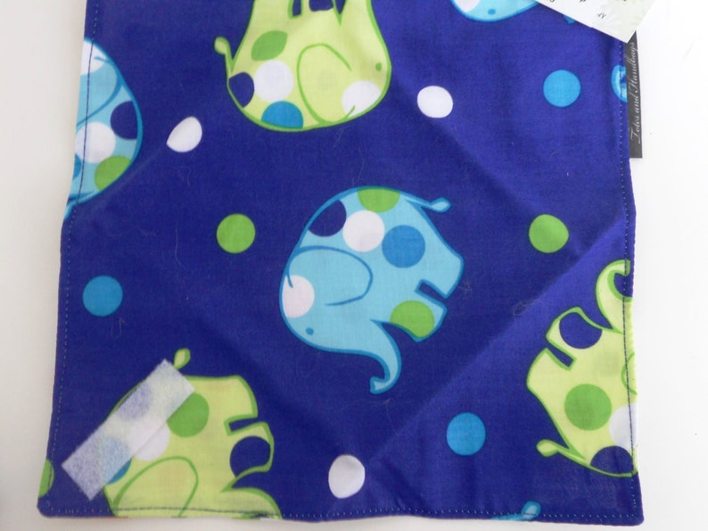 May include: Square blue fabric with a repeating pattern of cartoon elephants in light blue and lime green with white polka dots. The elephants are set against a dark blue background with white and green polka dots.