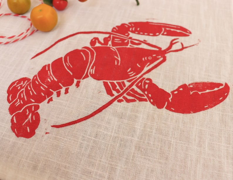 May include: Red lobster print on a white linen tea towel.