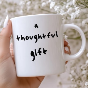 May include: White ceramic mug with a black handwritten message that reads "a thoughtful gift".