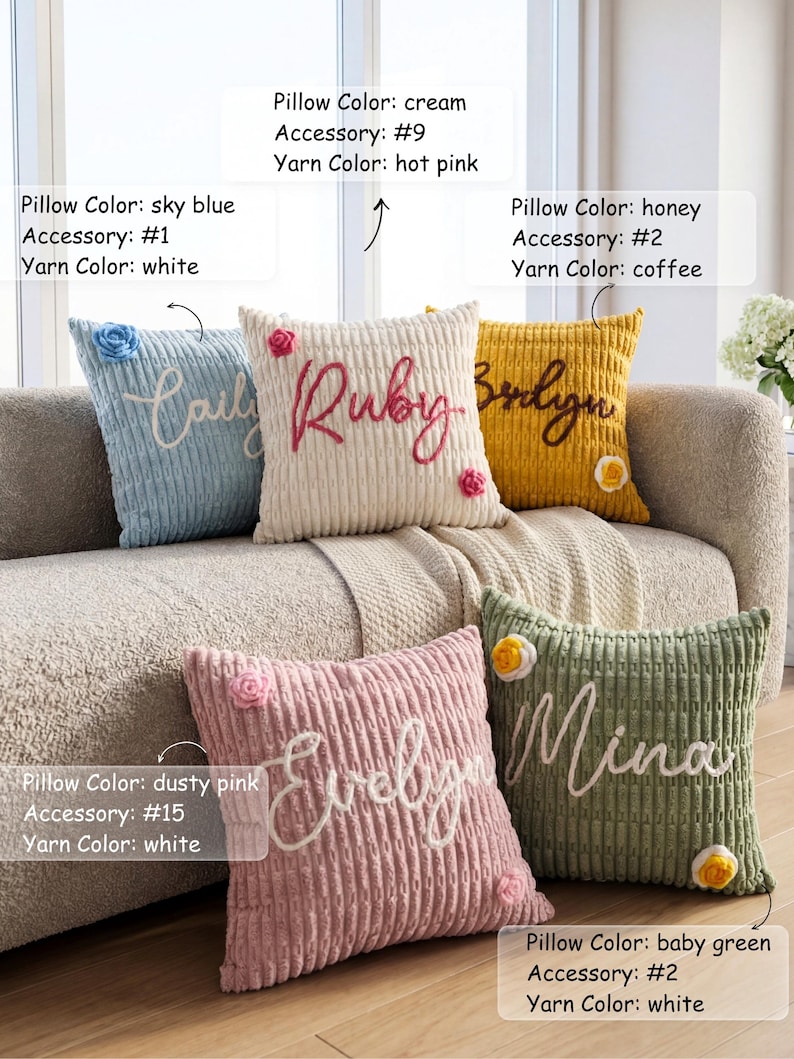 May include: Five square corduroy throw pillows in sky blue, cream, honey, dusty pink, and baby green. Each pillow features a custom embroidered name in cursive script and a small floral accessory. Text labels indicate pillow color, accessory number, and yarn color.