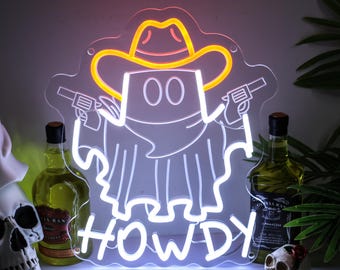 May include: A neon sign in the shape of a ghost wearing a cowboy hat and holding two guns. The word "HOWDY" is written in neon below the ghost. The sign is white with yellow and red accents.
