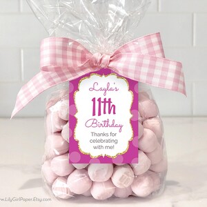 May include: Pink and gold birthday favor bag with a tag that says "Layla's 11th Birthday Thanks for celebrating with me!"
