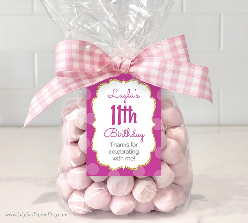 May include: Pink and gold birthday favor bag with a tag that says "Layla's 11th Birthday Thanks for celebrating with me!"