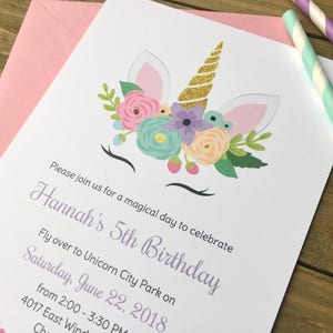 Op de afbeelding: Een witte kaart met een eenhoornillustratie en bloemmotieven. De kaart is een verjaardagsuitnodiging voor Hannah's 5e verjaardag. De uitnodiging bevat de datum, tijd en locatie van het feest.