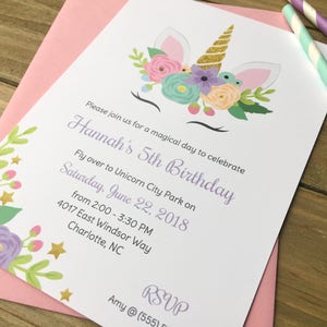 Op de afbeelding: Een witte uitnodiging met een eenhoornillustratie en bloemmotieven. De uitnodiging is voor Hannah's 5e verjaardagspartij in Unicorn City Park op zaterdag 22 juni 2018, van 14:00 tot 15:30 uur. Het adres is 4017 East Windsor Way, Charlotte, NC.