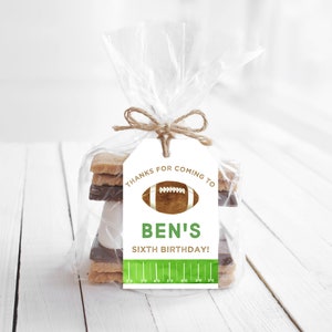 May include: A white gift tag with brown twine tied around it. The tag says "Thanks for coming to Ben's Sixth Birthday!" with a football graphic and green and white football field design.