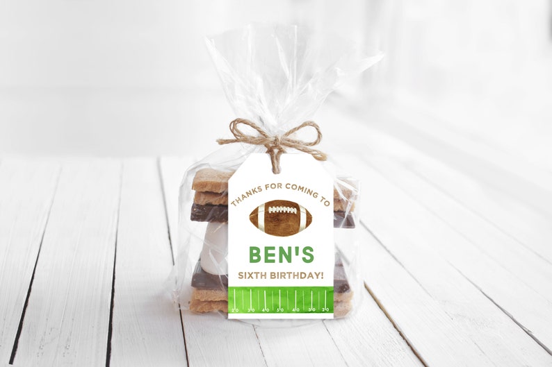 May include: A white gift tag with brown twine tied around it. The tag says "Thanks for coming to Ben's Sixth Birthday!" with a football graphic and green and white football field design.