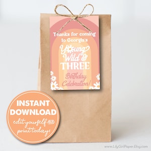 May include: A printable favor tag with a rainbow background and daisies. The text reads "Thanks for coming to Georgia's Young Wild & Three Birthday Celebration!"  The tag is attached to a brown paper bag with a twine bow.