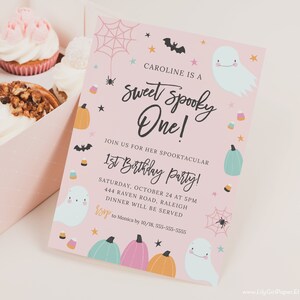May include: Pink and white invitation with a ghost and spider web design. The text reads "Caroline is a Sweet Spooky One!" and "Join us for her Spooktacular 1st Birthday Party!"  Saturday, October 24 at 5pm, 444 Raven Road, Raleigh. Dinner will be served. RSVP to Monica by 10/18, 555-555-5555.