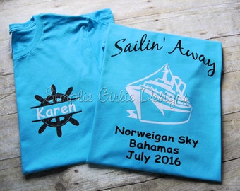 May include: Two turquoise blue t-shirts with black and white text and graphics. One shirt has a ship graphic and the text "Sailin' Away", "Norwegian Sky", "Bahamas", and "July 2016". The other shirt has a black and white steering wheel graphic with the name "Karen" in a white banner.