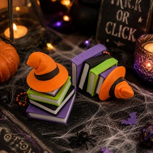 Può includere: Due pile di libri in miniatura in viola, nero e verde lime, ciascuna sormontata da un cappello da strega arancione brillante con una fascia nera. I libri hanno pagine bianche e sono disposti in una decorazione a tema Halloween.
