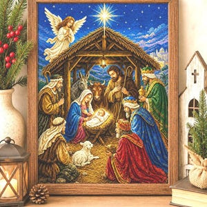 Può includere: Un'opera a punto croce incorniciata che raffigura una tradizionale scena della Natività. L'immagine mostra una stalla centrale sotto una stella luminosa, con figure di una famiglia, pastori e tre re che circondano un bambino in una mangiatoia.