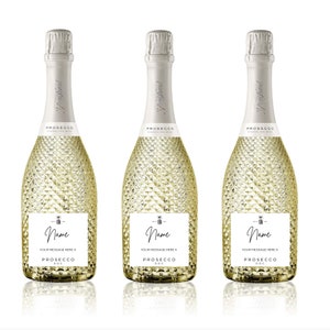 May include: Three clear glass bottles of Prosecco sparkling wine with gold textured glass. Each bottle has a white label with the text "Prosecco DOC" and a space for a personalised name and message.