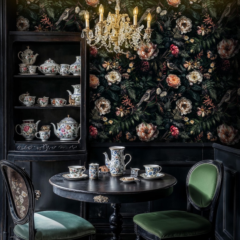 May include: A black and white floral wallpaper with a dark wood table set with a teapot, cups, and saucers. The table is surrounded by two chairs with green upholstery. A crystal chandelier hangs above the table.
