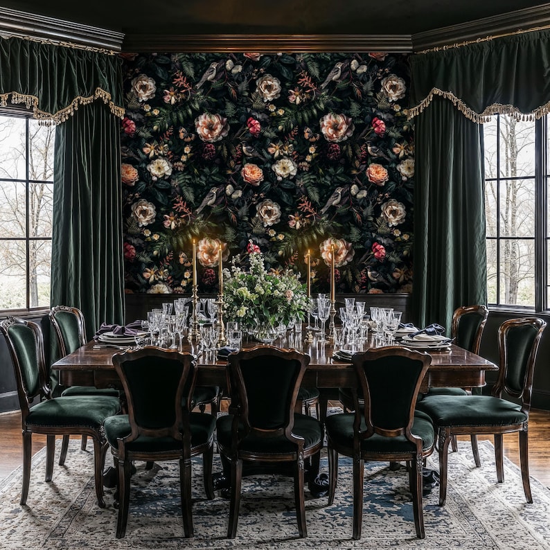 May include: A dark wood dining table set with black velvet chairs. The table is set with a floral centerpiece and glassware. The room has dark green velvet curtains and a floral wallpaper.
