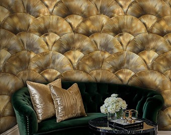 Puede incluir: Un sofá de terciopelo verde con almohadas doradas se encuentra frente a una pared cubierta con papel tapiz dorado en forma de abanico. Una mesa redonda negra y dorada con un jarrón de flores blancas se encuentra frente al sofá.