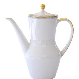 May include: White porcelain coffee pot with a long spout and curved handle. The lid is topped with a gold knob. Gold trim accents the rim, handle, and spout. A delicate gray and gold pattern decorates the lid's edge. The pot has a classic, elegant design.