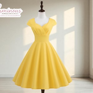 Peut inclure: Une robe jaune vif de style vintage avec un décolleté en cœur et des manches courtes. La robe présente un corsage ajusté et une jupe évasée, présentée sur un mannequin. La robe est en tissu lisse et convient aux occasions spéciales.