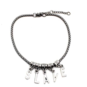 May include: A silver-toned chain bracelet with the word "SLAVE" spelled out in individual silver letters. The bracelet has a delicate chain design and is set against a white background.