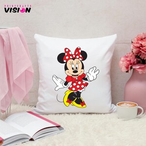 May include: White pillow with a red and white polka dot Minnie Mouse design. Minnie Mouse is wearing a red dress with white polka dots and a red bow. She is smiling and waving.
