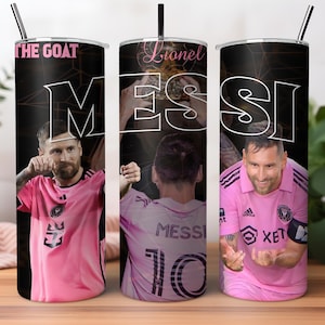 May include: Three stainless steel tumblers with black and white designs featuring a soccer player wearing a pink jersey with the name "Messi" and the number "10" on the back. The tumblers have black backgrounds with white text that reads "Lionel Messi" and "The Goat".