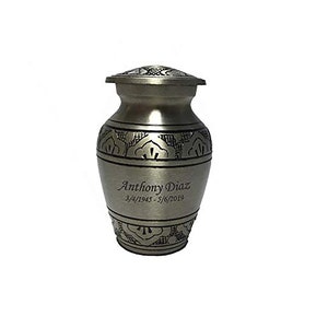 May include: Silver metal cremation urn with an engraved floral design and the inscription "Anthony Diaz 3/4/1945 - 3/6/2019".