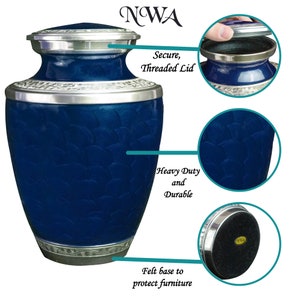 May include: Blue metal cremation urn with a silver lid and base. The urn has a textured design and a felt base to protect furniture. The lid is threaded and secure. "NWA" is written on the top of the image.