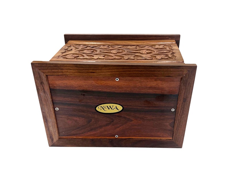 May include: A wooden box with intricate carvings on the top and a gold label on the front that reads "NWA".