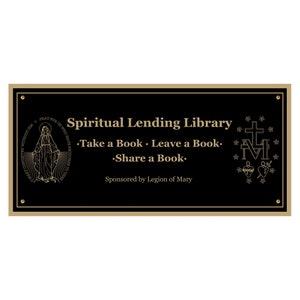Puede incluir: Una placa negra con letras doradas que dice "Spiritual Lending Library - Take a Book - Leave a Book - Share a Book - Sponsored by Legion of Mary". La placa presenta una imagen dorada de la Virgen María a la izquierda y una imagen dorada de la Medalla Milagrosa a la derecha.