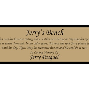 May include: A gold plaque with black trim and gold screws reads "Jerry's Bench". The plaque has a brown background and black text that reads "This was his favorite resting place. Either just sitting or "Resting his eyes." This is where Jerry sat. In his older years, this was the spot Jerry played fetch with his dog, Tiger. May his memories live on and his soul be at rest. In Loving Memory Of Jerry Pasquel."
