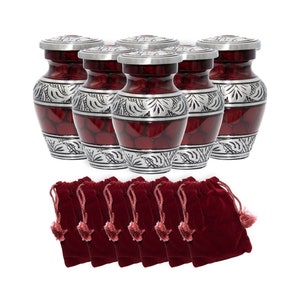 May include: Set of six small red and silver metal urns with ornate designs. Each urn comes with a matching red velvet bag.