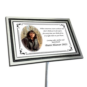 Puede incluir: Una placa conmemorativa de metal plateado con borde negro y una foto de una mujer en un bosque. La placa tiene un poema sobre recordar a alguien que ha fallecido y el texto "Loving wife, mother and dear friend. Patti Hoover 2021".