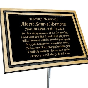May include: A black granite memorial plaque with gold lettering. The plaque reads "In Loving Memory Of Albert Samuel Ramona Nov. 30 1990 - Feb. 12 2023" and includes a poem about remembering a loved one.