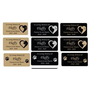 May include: Nine different memorial plaques with the name "Fluffy" and the years 2010-2020. Each plaque has a different design with a heart, paw prints, or a cat or dog silhouette.
