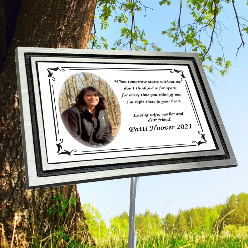 Puede incluir: Una placa conmemorativa de plata con borde negro y fondo blanco. La placa tiene una foto de una mujer en un entorno boscoso. El texto en la placa dice: "Cuando ma&ntilde;ana empiece sin m&iacute;, no pienses que estamos lejos, porque cada vez que pienses en m&iacute;, estoy ah&iacute; en tu coraz&oacute;n. Esposa cari&ntilde;osa, madre y querida amiga. Patti Hoover 2021"
