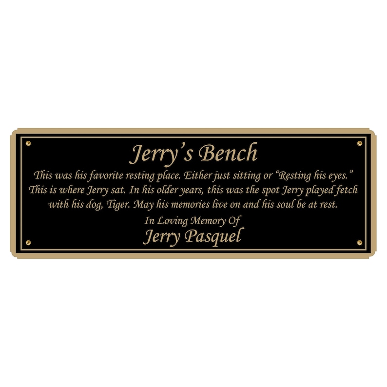 K&ouml;nnte beinhalten: Eine schwarze Plakette mit goldener Umrandung und goldenen Buchstaben tr&auml;gt die Aufschrift "Jerry's Bench". Die Plakette enth&auml;lt eine Botschaft &uuml;ber Jerrys Lieblingsruheplatz und eine Hommage an sein Andenken.