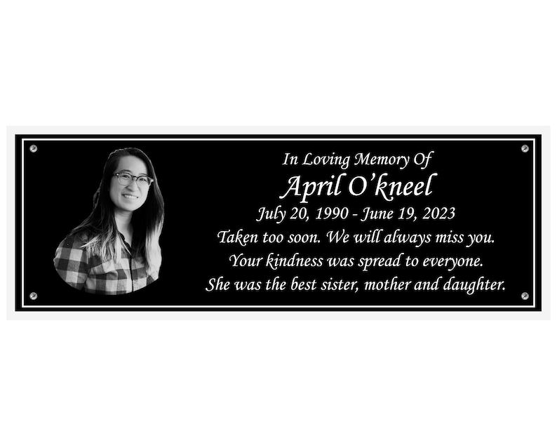 May include: Black and white memorial plaque with a photo of a woman and the text "In Loving Memory Of April O'kneel July 20, 1990 - June 19, 2023 Taken too soon. We will always miss you. Your kindness was spread to everyone. She was the best sister, mother and daughter."