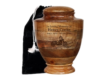Könnte beinhalten: Eine Holurne mit einem eingravierten Motorradmotiv. Die Urne ist braun und wird mit einem schwarzen Samtbeutel geliefert. Die Urne ist mit "In Loving Memory Of Henry Cooke Aug 1, 1970 - July 22, 2022" beschriftet.