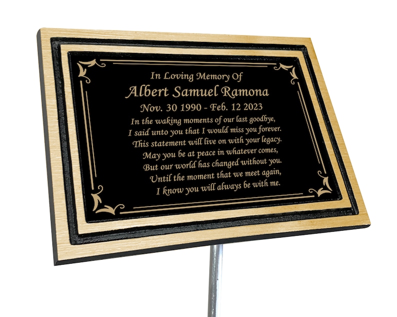 May include: A black and gold memorial plaque with a poem inscribed in gold lettering. The plaque reads "In Loving Memory Of Albert Samuel Ramona Nov. 30 1990 - Feb. 12 2023 In the waking moments of our last goodbye, I said unto you that I would miss you forever. This statement will live on with your legacy. May you be at peace in whatever comes, But our world has changed without you. Until the moment that we meet again, I know you will always be with me."