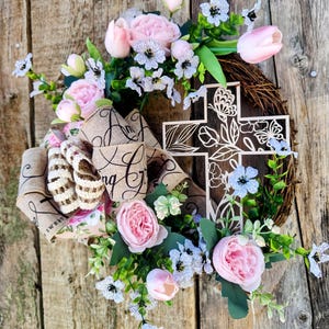 Gorgeous Easter wood cross wreath with pink roses, pink tulips, white violas and greenery and a beautiful bow with Amazing Grace.