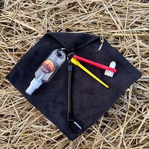 May include: A black microfiber cleaning cloth with a small clear spray bottle, a yellow and red cleaning brush, and a black retractable keychain.