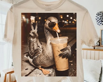 Ganso bebiendo café helado PNG, Ganso gracioso PNG, Ganso con café PNG, Meme de animales gracioso PNG, PNG prehistórico retro, Regalo para amantes de los animales