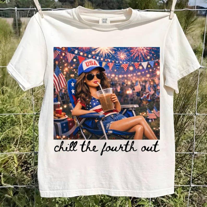 May include: Cream-colored t-shirt featuring a graphic of a person in a patriotic scene, wearing a USA hat and sunglasses, enjoying a drink. The image includes fireworks and American flags. The text "chill the fourth out" is written below the graphic.