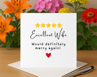 以下が含まれることがあります： 白いカードに、黄色の星が5つと、「Excellent Wife」という黒い筆記体で書かれた文字があります。星の真下に、「Would definitely marry again!」という黒い文字で書かれた文字があります。文字の下には赤いハートがあります。