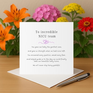 Puede incluir: Una tarjeta blanca con el texto "To incredible NICU team" y un mensaje de agradecimiento. La tarjeta está sobre una superficie de madera, con un bolígrafo y flores coloridas en el fondo, incluyendo lirios naranjas, hortensias rosas y flores rojas y amarillas.