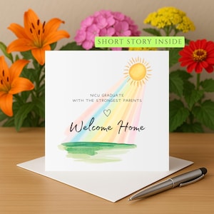 Puede incluir: Una tarjeta de felicitación blanca con las palabras «Welcome Home» y «NICU Graduate with the Strongest Parents». La tarjeta presenta un sol con rayos de arcoíris y un corazón. Un bolígrafo descansa sobre el sobre.