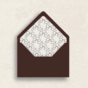 Peut inclure: Une enveloppe marron ouverte, révélant un intérieur crème orné d'un motif répété de nœuds noirs. Le design est simple et élégant, idéal pour la papeterie ou les invitations, avec une esthétique classique.